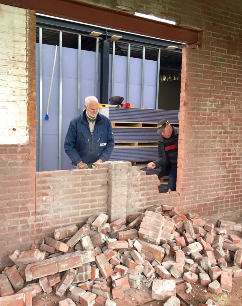 Willem en Henk rammen er op los, de vrijwilligers maken de doorgang naar het hoofdveld in de tribune